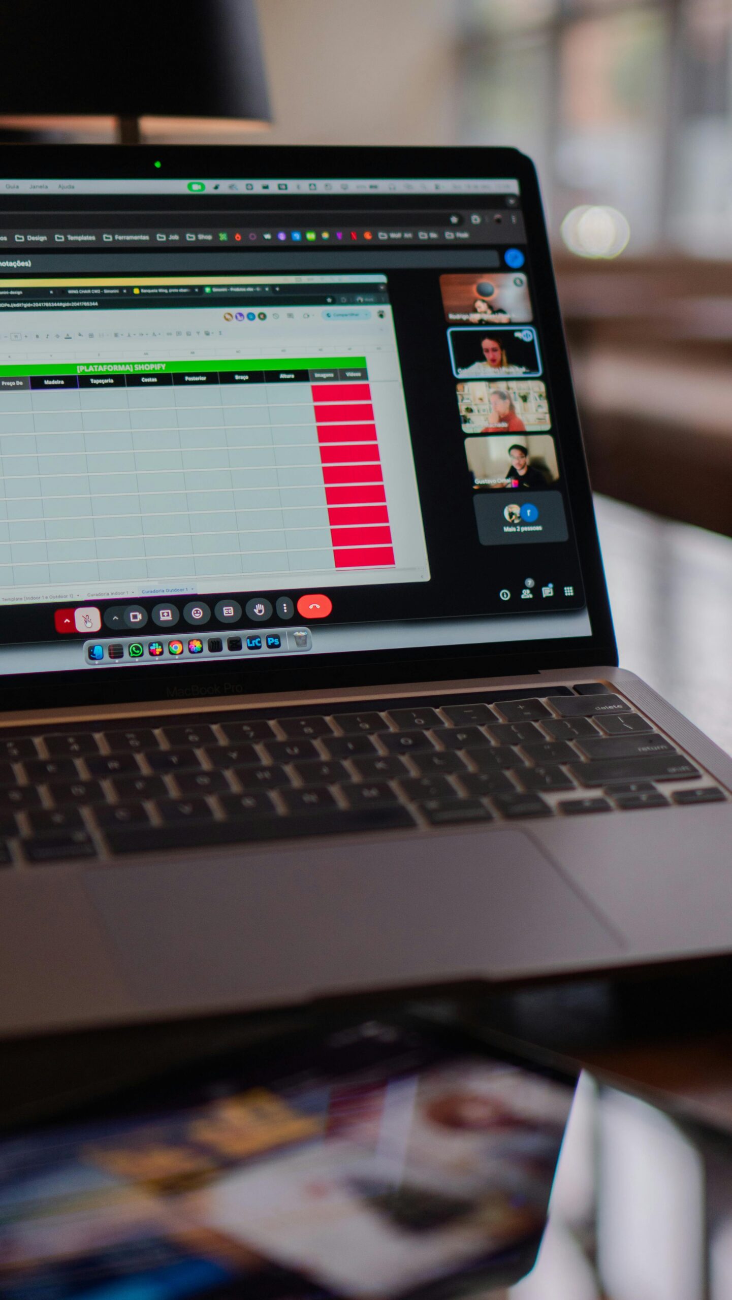 Laptop displaying a remote video meeting in a modern office setting.